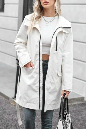 White water-resistant windbreaker trench jacket with black zipper and belt, worn over casual outfit.