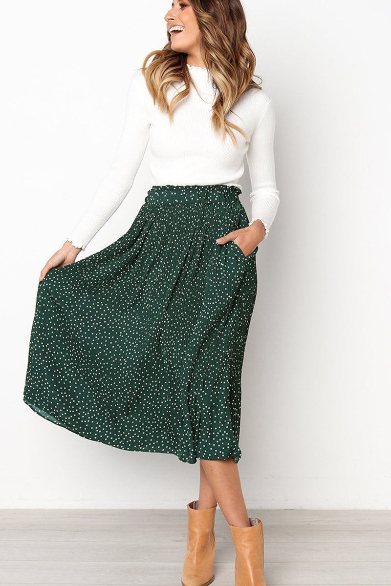 Woman wearing effortlessly chic polka dot pleated high-waist midi skirt with pockets and white long-sleeve top