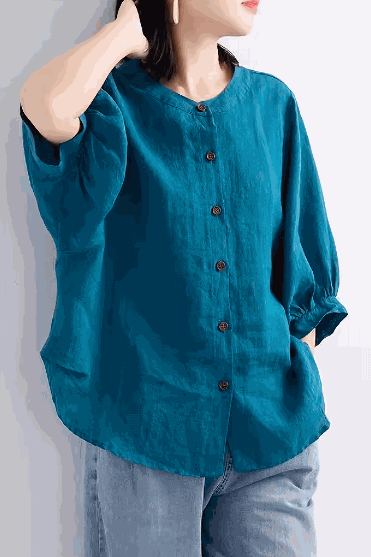 Relaxed loose breathable linen blouse in teal with button-down front and three-quarter sleeves.