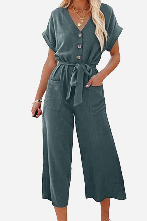 Woman wearing a V-neck lace-up pocket jumpsuit with tie waist and wide-leg pants in dark green