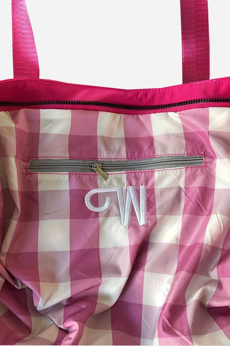 Pink and white checkered waterproof travel bag interior with zipper pocket and pink handles