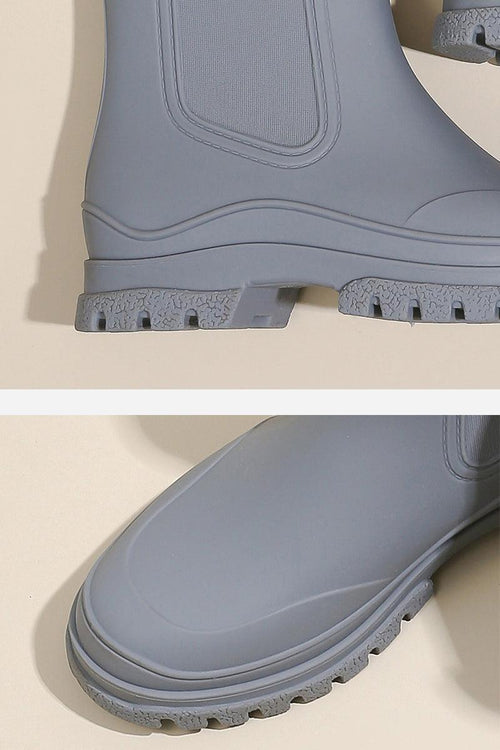 Close-up of grey waterproof non-slip rain boots with textured SuperGrip soles for enhanced traction and comfort.