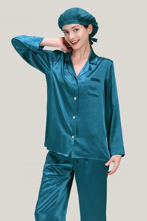 Woman wearing teal classic mulberry silk pajama set with matching sleep cap, long sleeve button-down top and wide-leg pants.