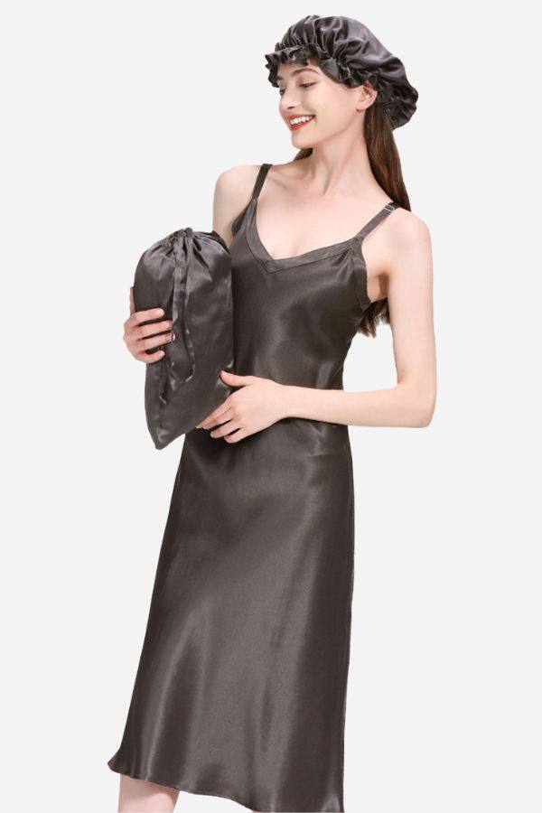 Woman wearing charcoal mulberry silk elegant night dress with matching sleep cap and pouch.