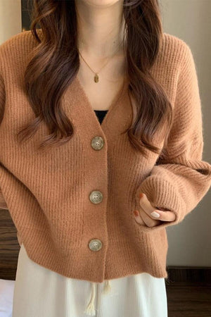 Woman wearing a soft brown casual loose boxy cardigan with buttons and ribbed texture