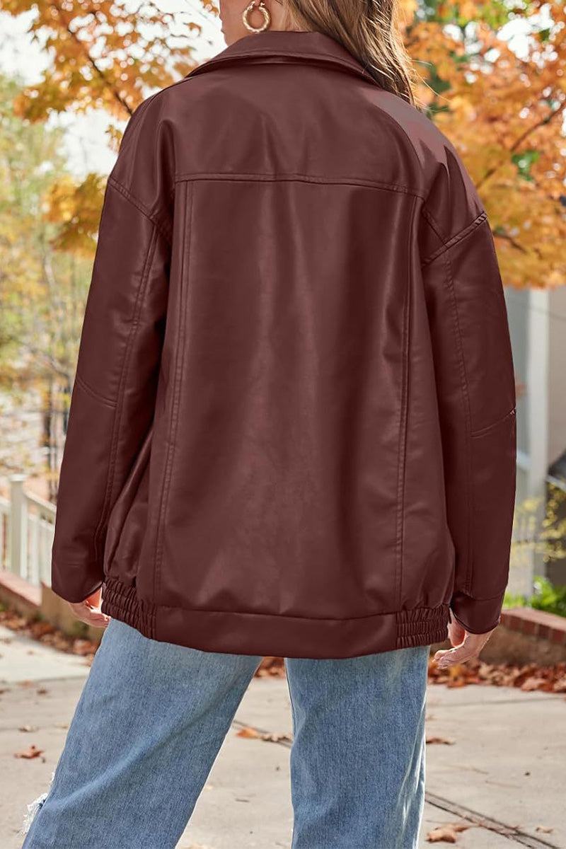 Oversized faux leather motorcycle jacket in burgundy with a relaxed fit worn outdoors in autumn