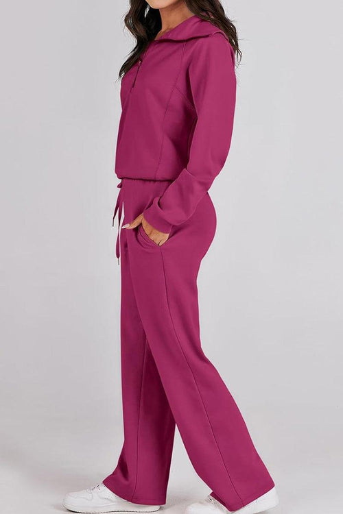 Woman wearing a magenta oversized loungewear buttersoft tracksuit set with drawstring waist and white sneakers.