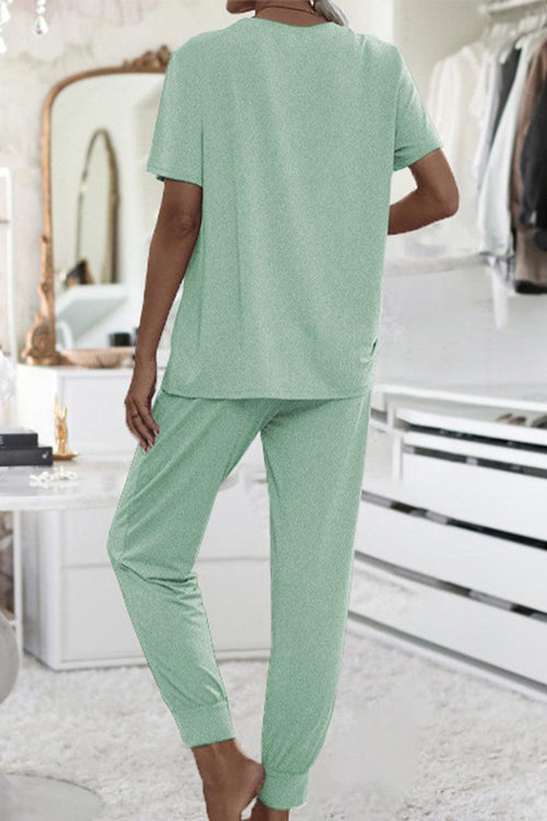 Back view of woman wearing mint green ultra-soft two-piece loungewear set with short sleeves and jogger pants in cozy indoor setting