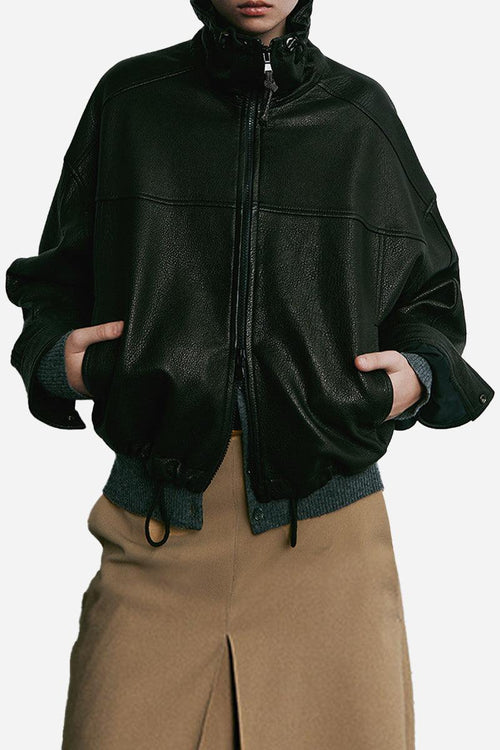 black sheepskin leather jacket with zip front and elastic hem worn with tan skirt