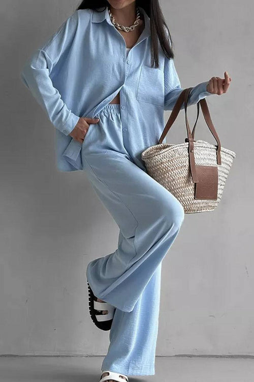 Woman wearing light blue wide-leg two-piece set with relaxed fit and carrying woven tote bag