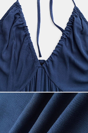 Close-up of navy blue Sunshine On Sand halter-neck jumpsuit fabric and ruched neckline detail