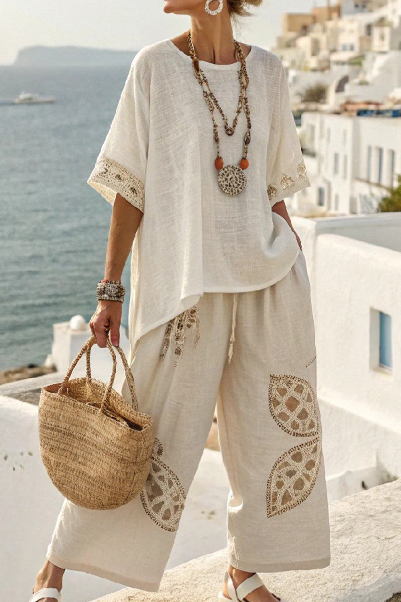 Woman wearing Coastal Comfort Linen two-piece set with crochet details, holding woven bag by seaside terrace