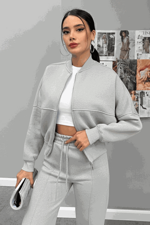 Woman wearing The Voyager Zip Set light grey zip-front sweatshirt and wide-leg joggers with pockets, stylish travel outfit