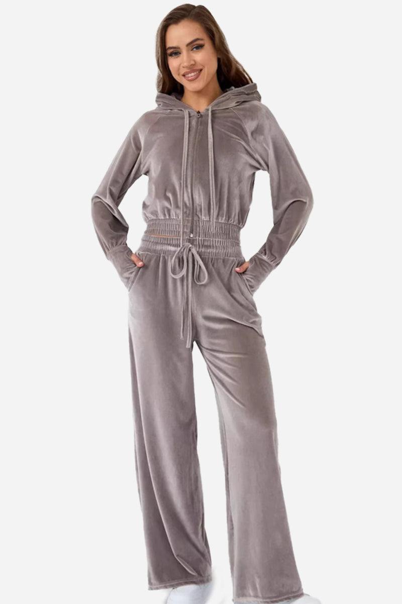 Woman wearing grey velour tracksuit with cropped hoodie and high-waist pants