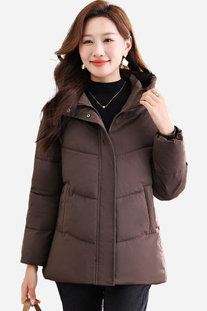 Woman wearing mid-length brown Everyday Warmth Coat with hood and zip front