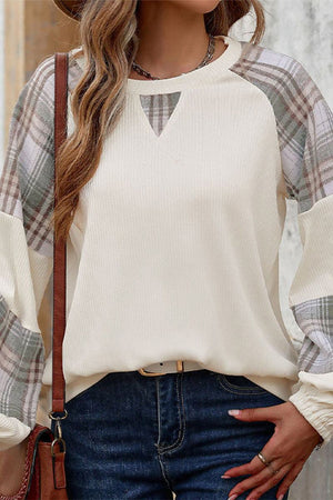 Waffle knit sweatshirt with plaid sleeves and v-notch neckline worn with jeans