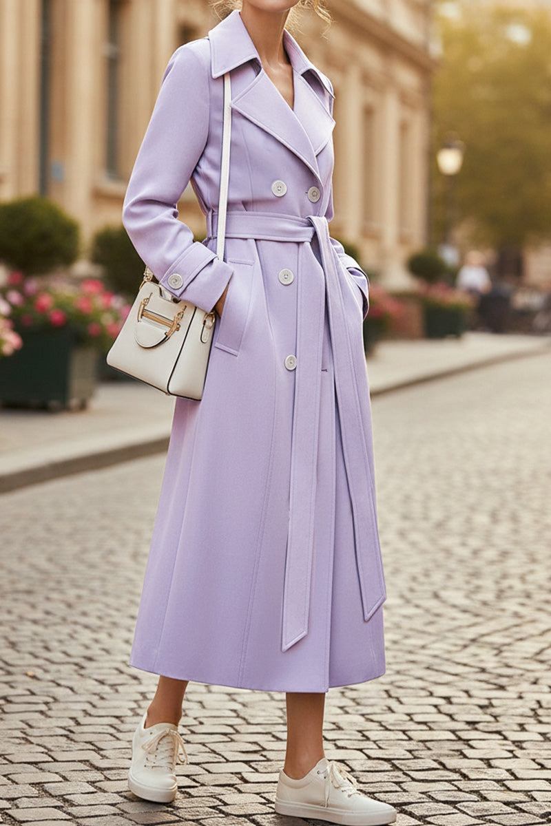 Woman wearing lavender timeless retro belted trench coat with double-breasted buttons and wide lapels walking outdoors