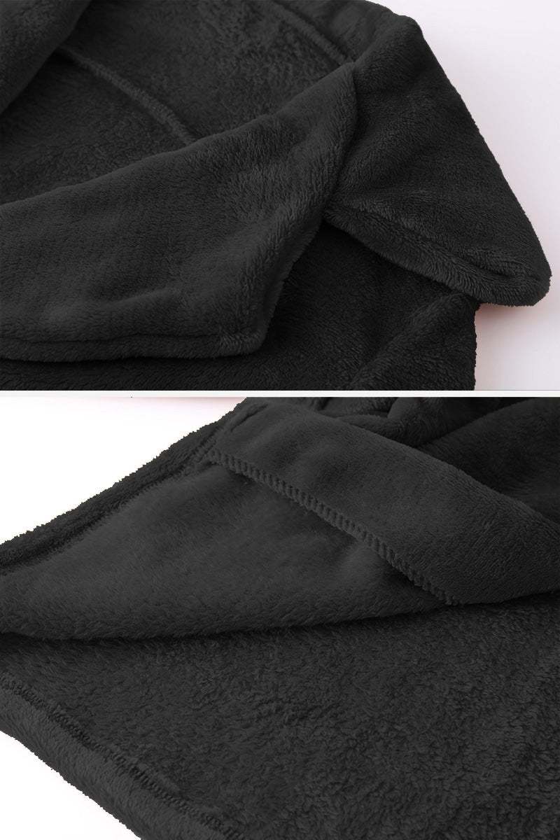 Close-up of soft black faux fur fabric on open front oversized fur jacket with plush shawl collar and smooth lining