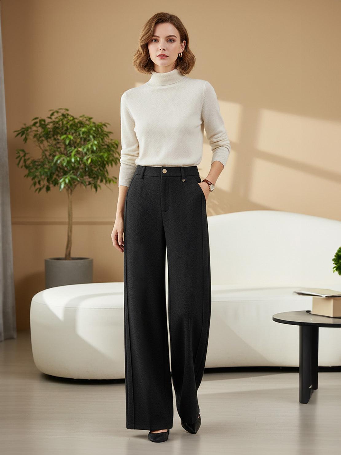 Woman wearing black thermal wool blend trousers with wide-leg cut and high waist in modern office setting