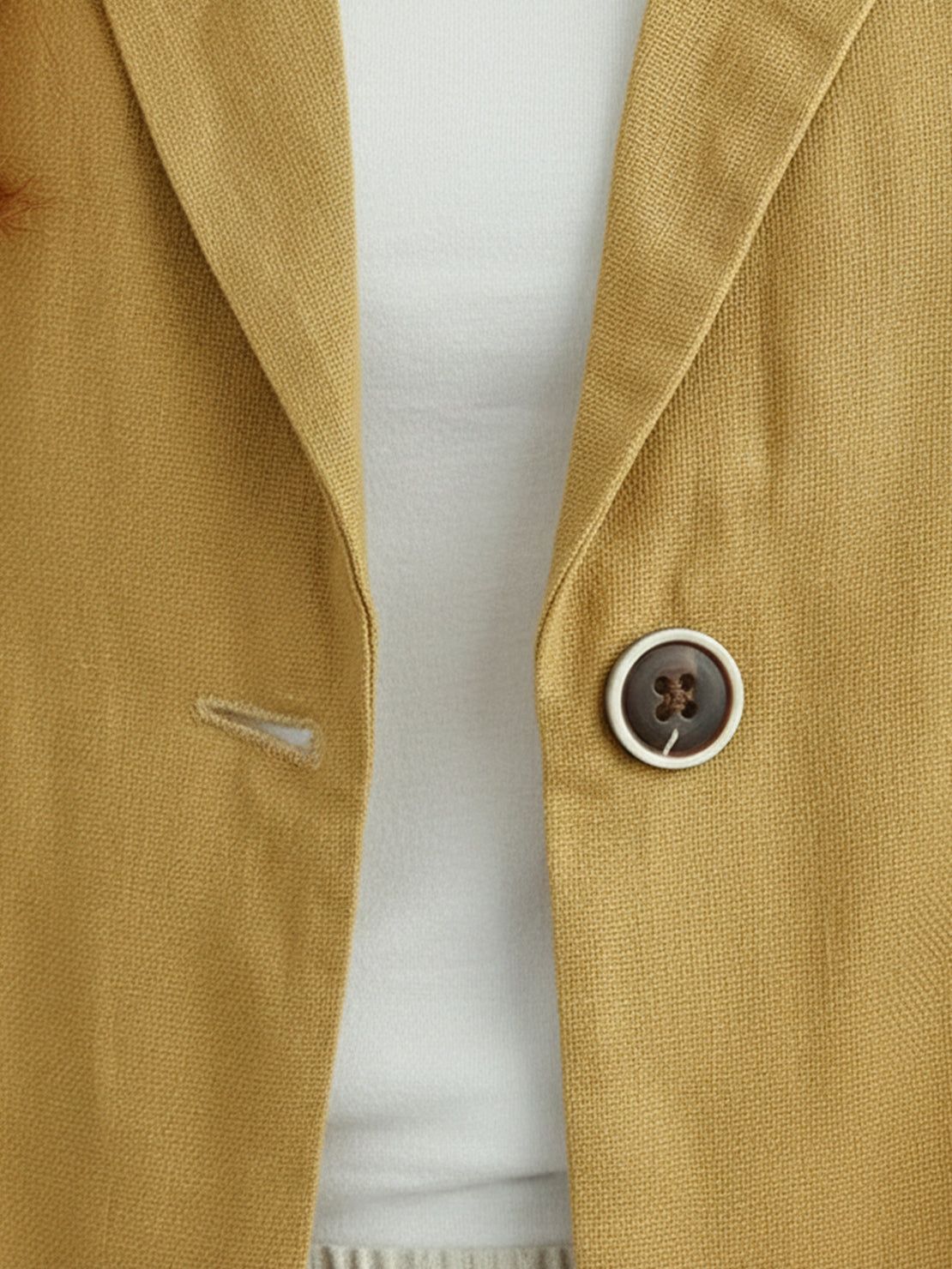 Cotton-linen blazer with notch lapels, two-button front, patch pockets, and natural textured fabric.