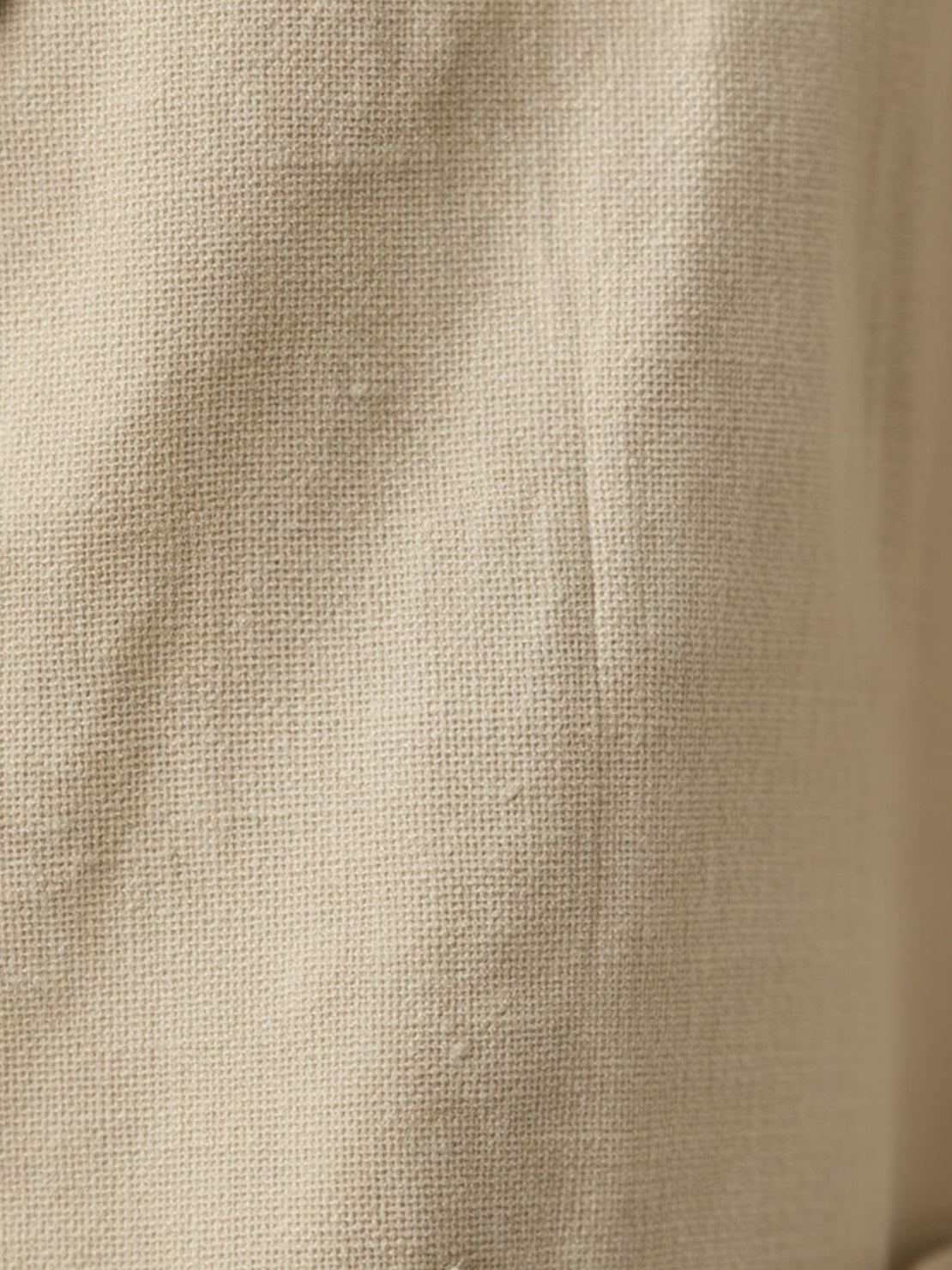 Hip-length cotton-linen blazer with notch lapels and two-button closure, featuring patch pockets and natural textured fabric.