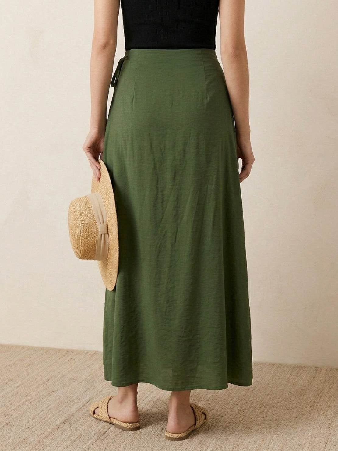 Woman wearing asymmetrical wrap maxi skirt with side tie closure and flowing asymmetric hem