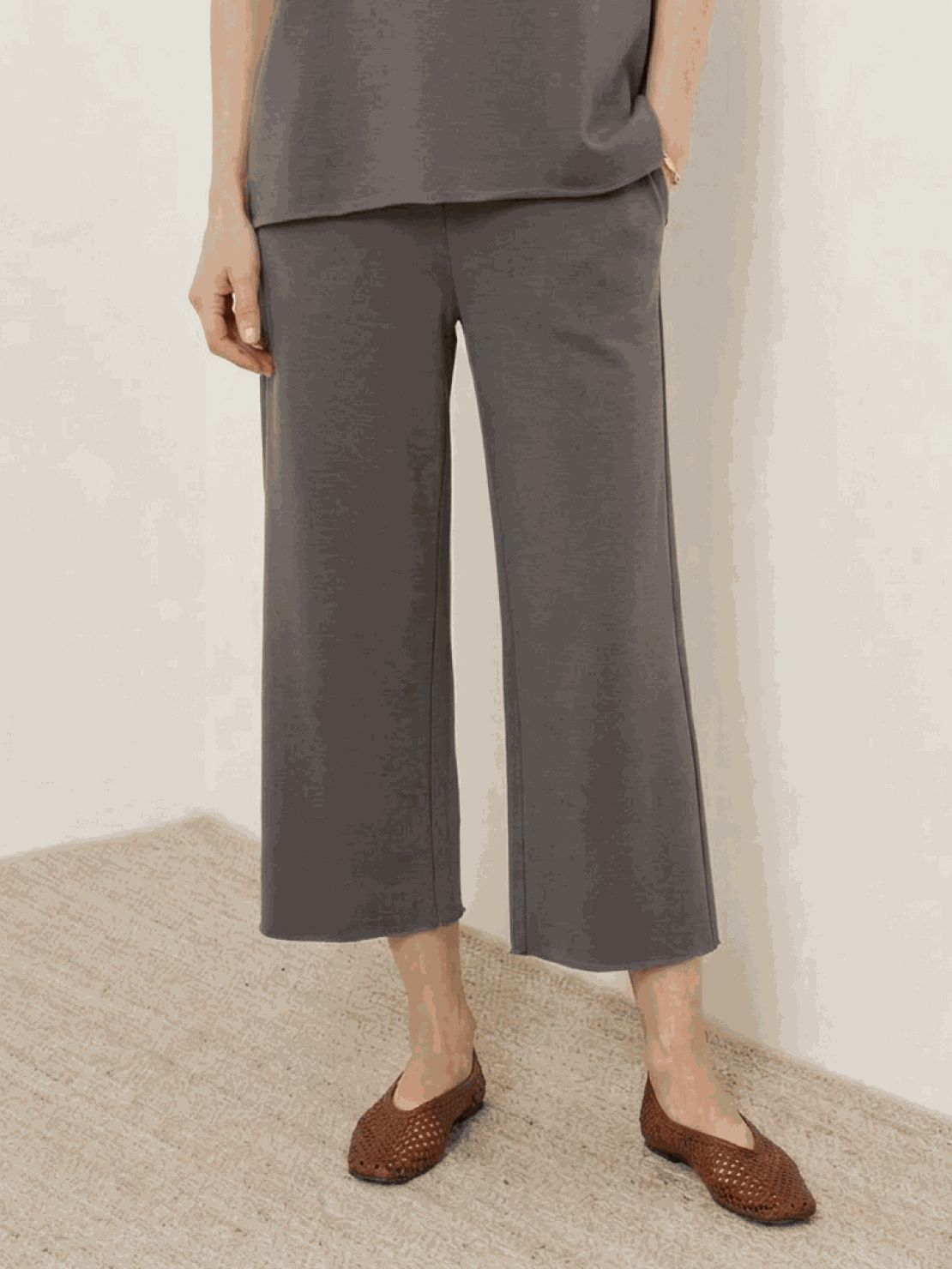 Woman wearing a cotton-blend capelet top with batwing sleeves and wide-leg pants lounge set in neutral color