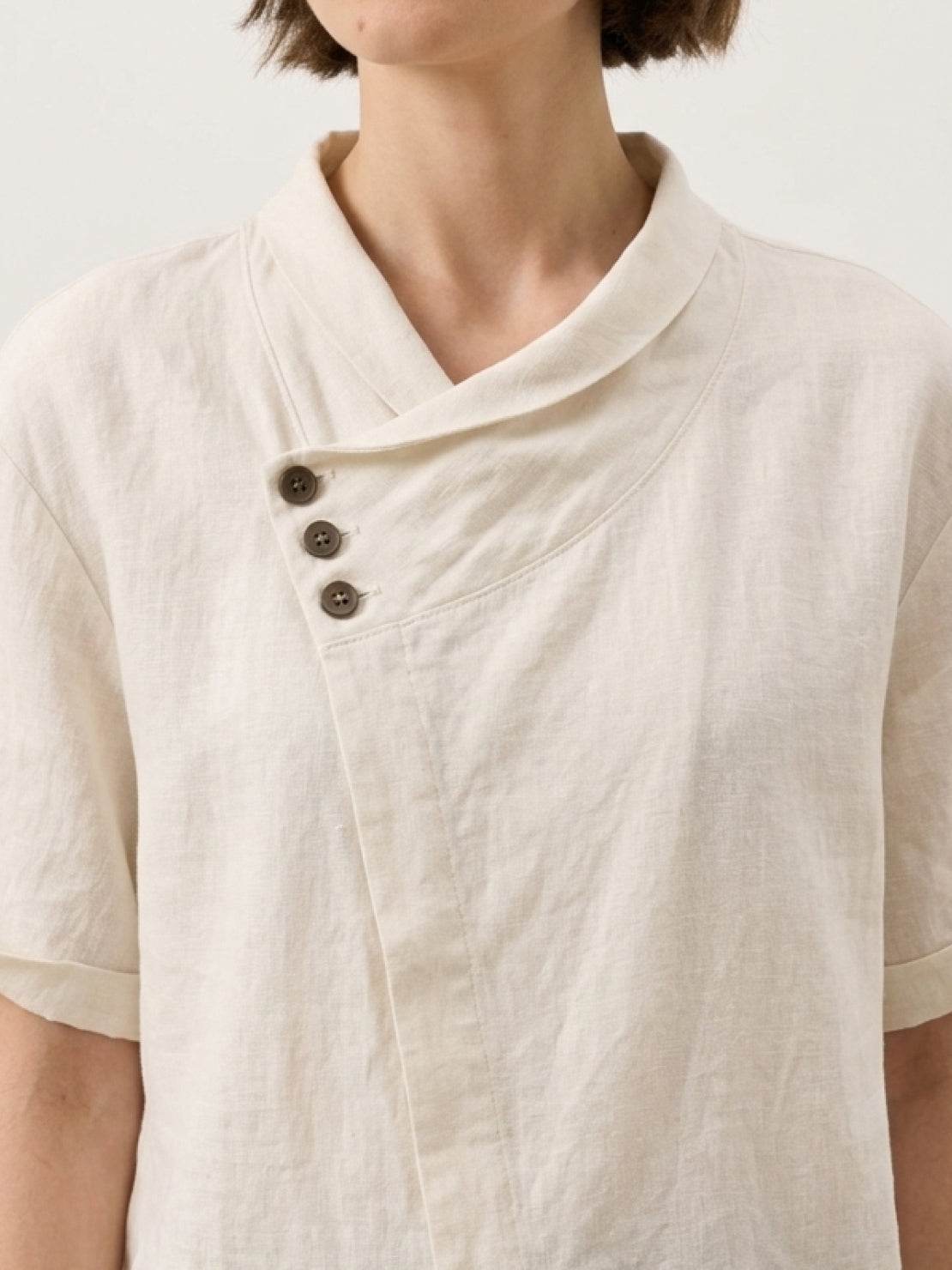 Women wearing relaxed 100% linen V-neck top with asymmetric button detail in navy, pastel pink, and cream colors