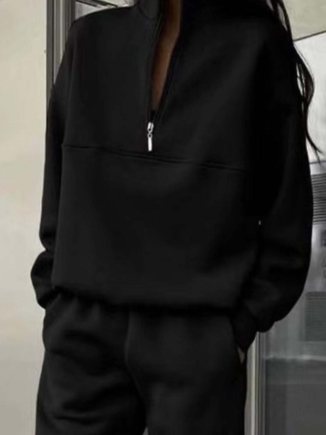 Woman wearing a stylish cotton-blended two-piece tracksuit with high collar and zipper outdoors