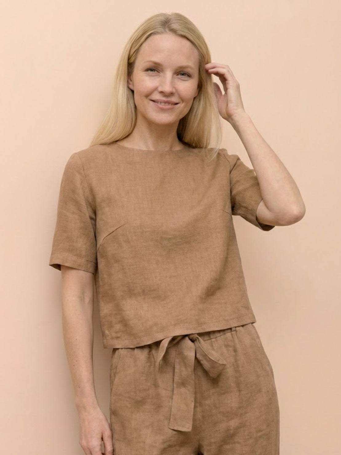 Woman wearing a relaxed cotton linen monochrome short-sleeve top with natural texture and breathable fabric