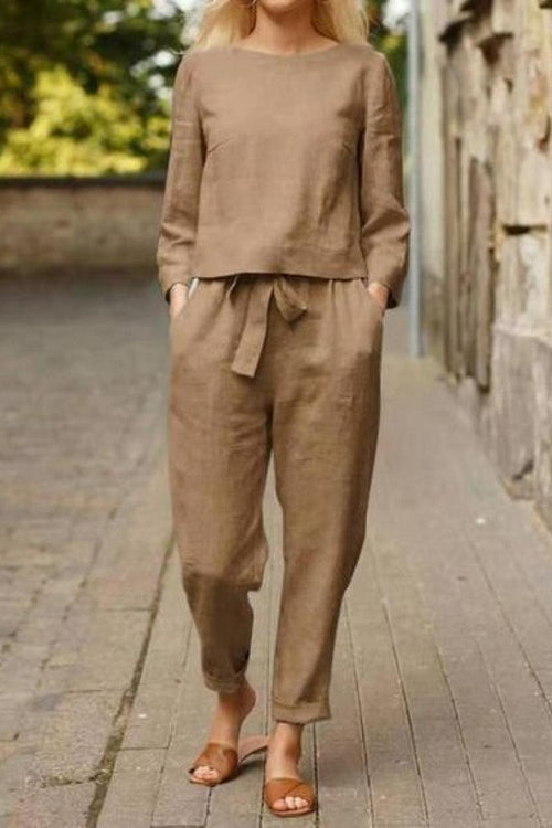 Woman wearing relaxed cotton-linen monochrome taupe top and wide-leg pants set with sandals walking outdoors