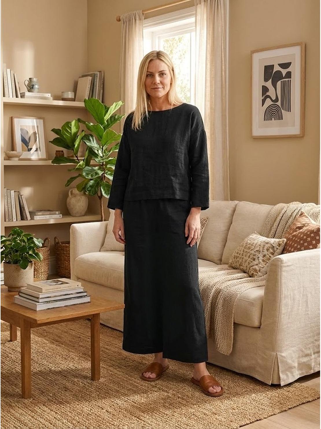 Woman wearing a loose solid color black two-piece set with wide-leg pants in a cozy living room.