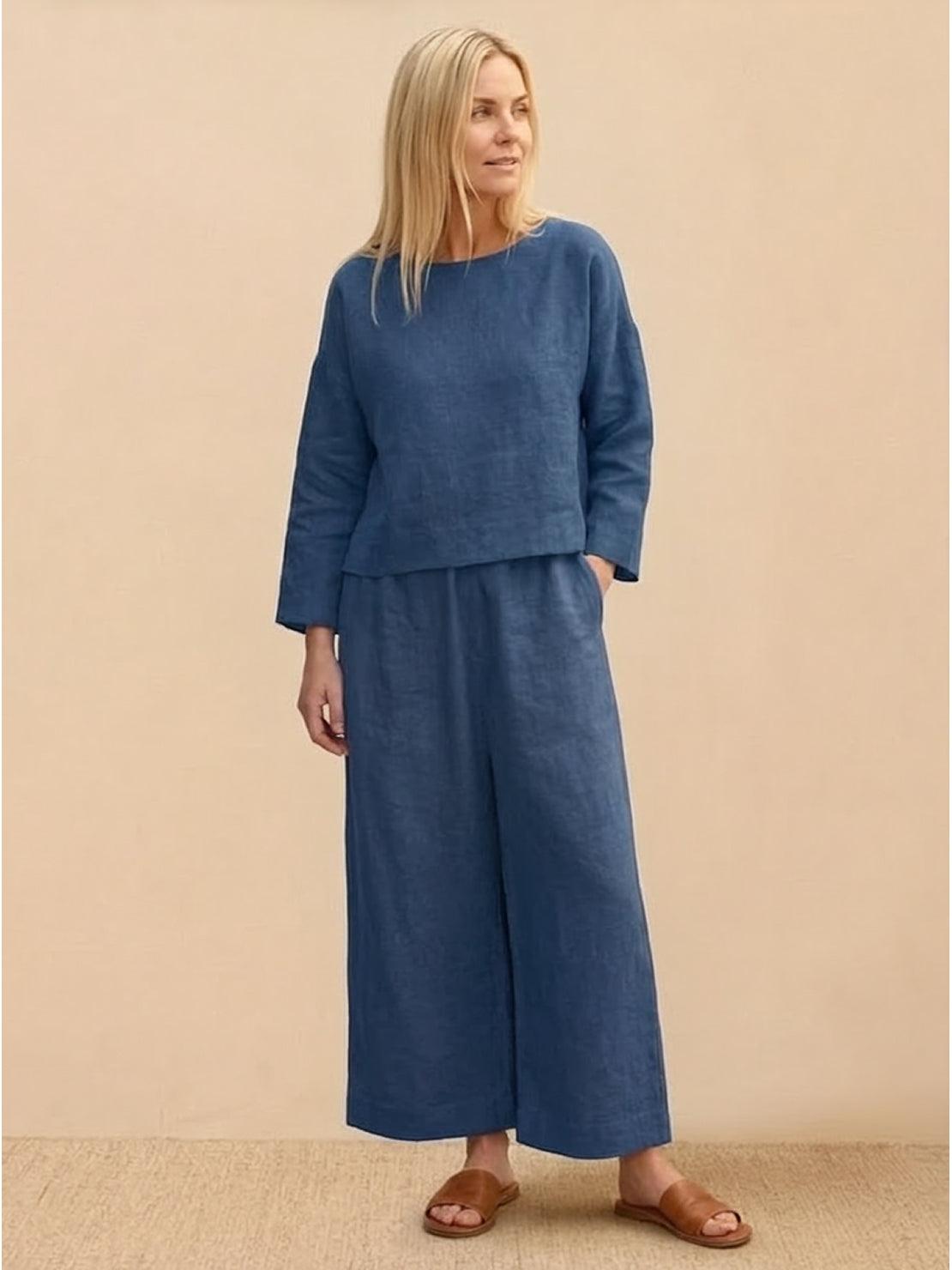Woman wearing loose solid color two-piece set with round-neck top and wide-leg pants in a minimalist setting
