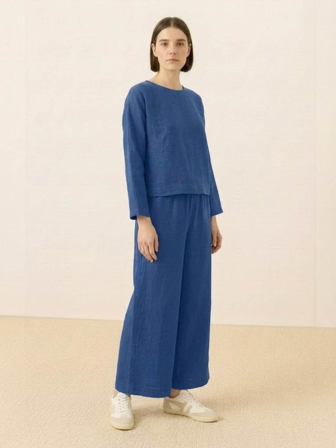 Woman wearing loose solid color two-piece set with wide-leg pants and round-neck top.
