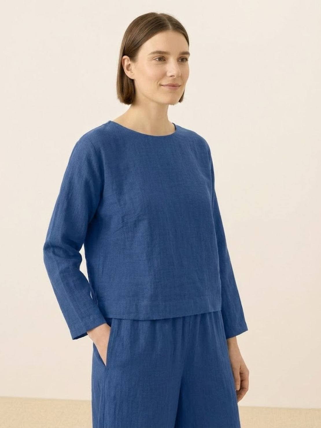 woman wearing loose solid color two-piece set with round-neck pullover and wide-leg pants in soft breathable fabric