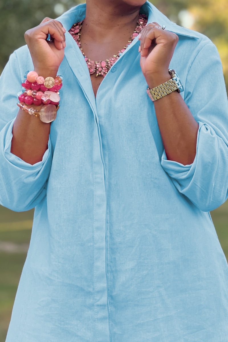 Light blue oversized 100% cotton shirt with relaxed sleeves worn with bracelets and a necklace