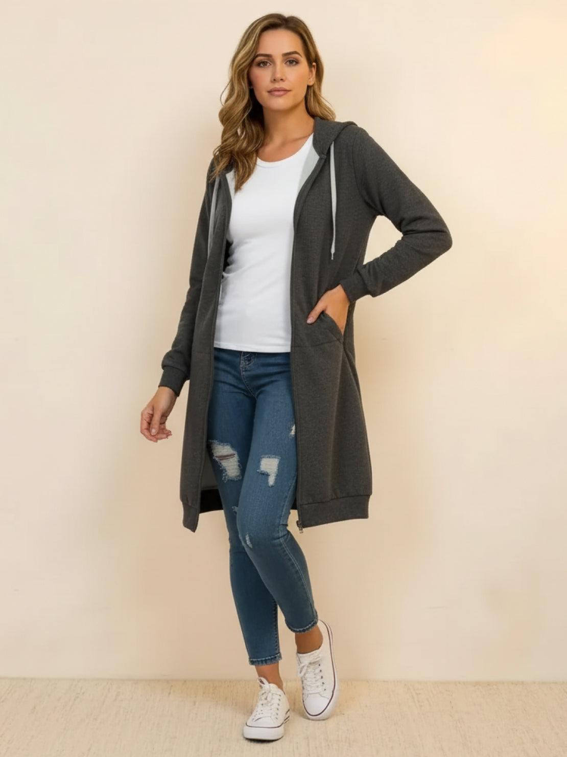 Woman wearing oversized long zip sweatshirt hoodie in dark gray with hood and front pockets