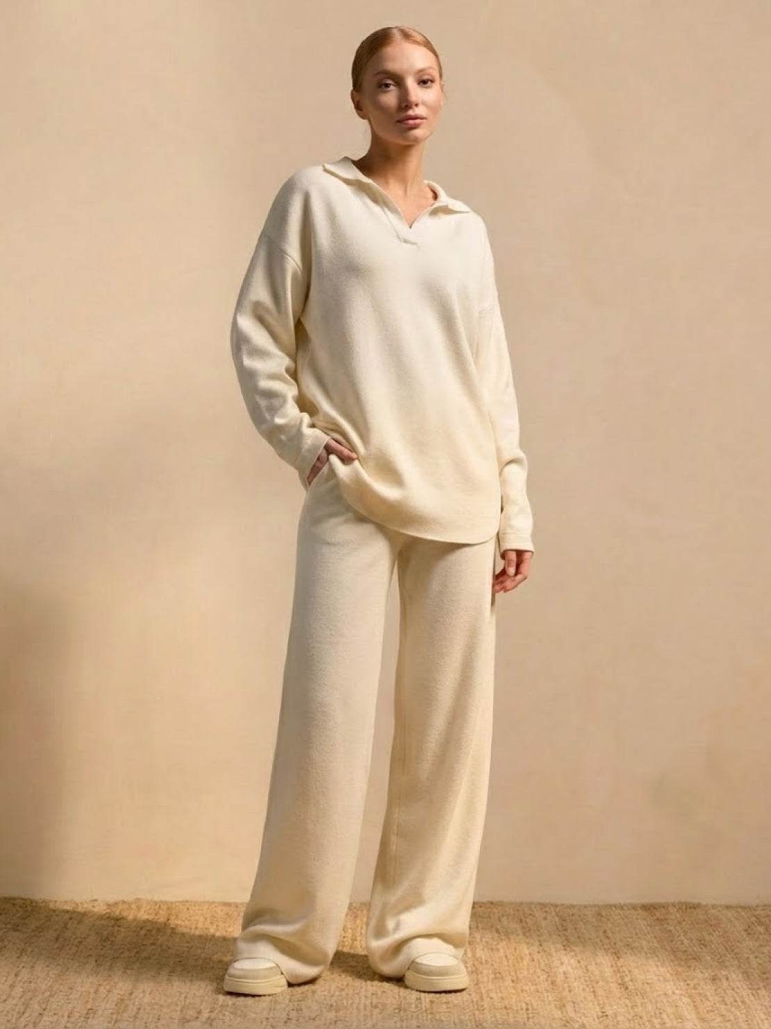 woman wearing plush preppy camel two-piece set with polo collar and wide-leg pants against beige background