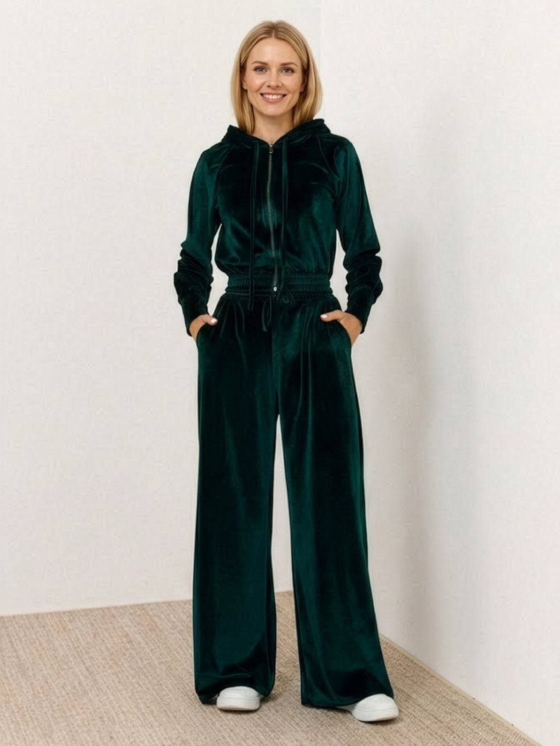 Woman wearing a modern cropped velour tracksuit with a hoodie and high-waist pants in vibrant color