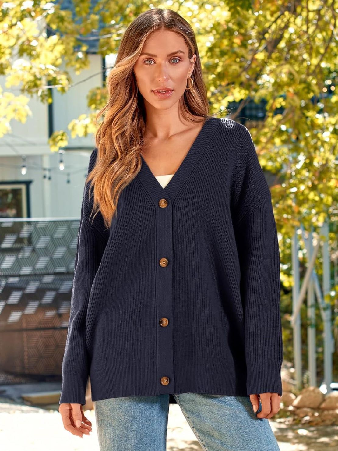 Woman wearing relaxed fit oversized black knitwear cardigan with button down front outdoors