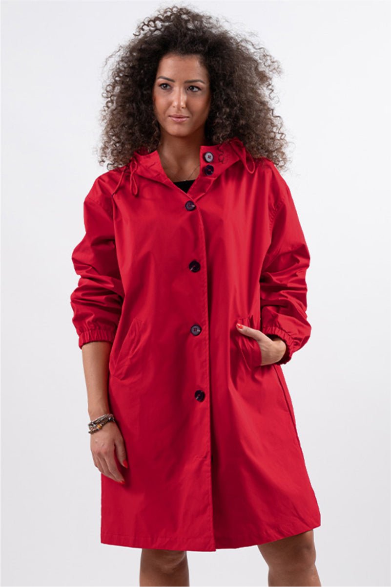 Woman wearing a trendy oversized red Rain Couture Windbreaker jacket with hood and button closure