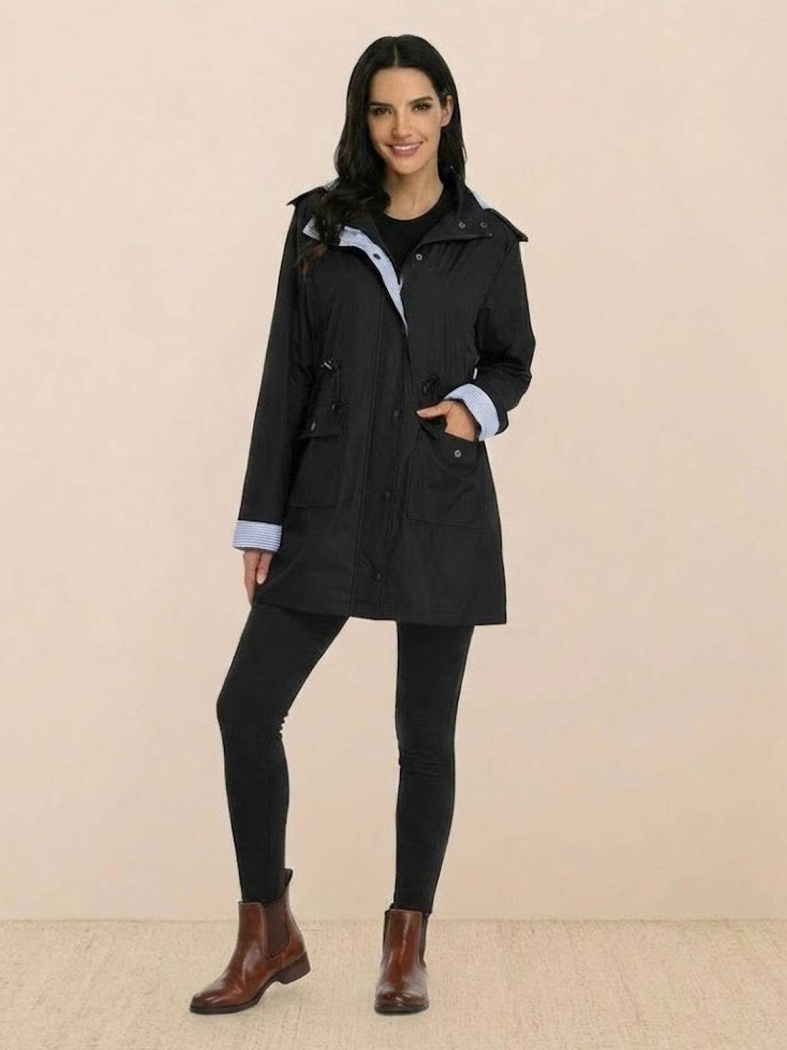 woman wearing black water resistant windbreaker hooded rain jacket with pockets and rolled cuffs
