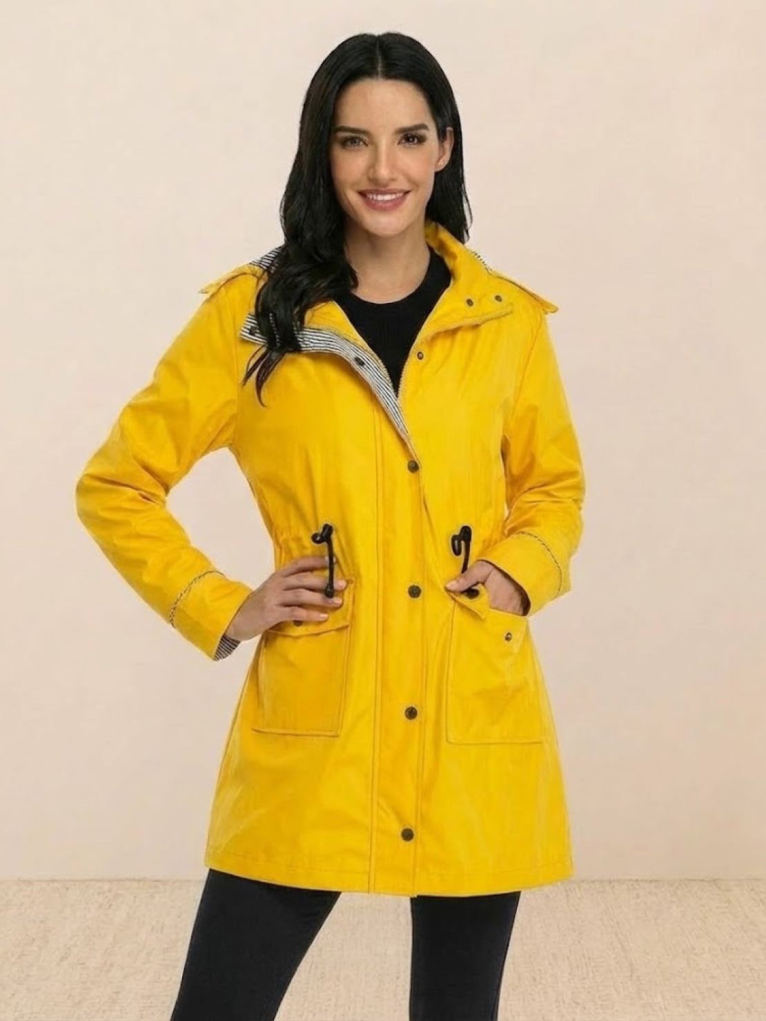 woman wearing yellow water resistant windbreaker with hood and front pockets