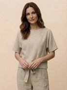 Woman wearing relaxed cotton linen set with short-sleeve top and straight-leg pants in monochrome tone
