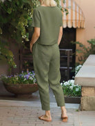 Woman wearing relaxed cotton linen set with short-sleeve top and straight-leg pants in monochrome style