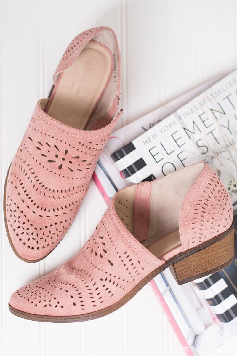 Pink laser cut western ankle boots with low wooden heels and side zipper on white background