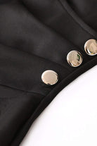 Close-up of stylish button pencil dress with gold buttons on black fabric