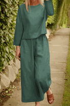 Women wearing loose solid color two-piece set with long sleeves and wide-leg pants outdoors