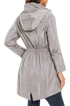 Woman wearing gray outdoor and travel hooded raincoat windbreaker jacket from the back
