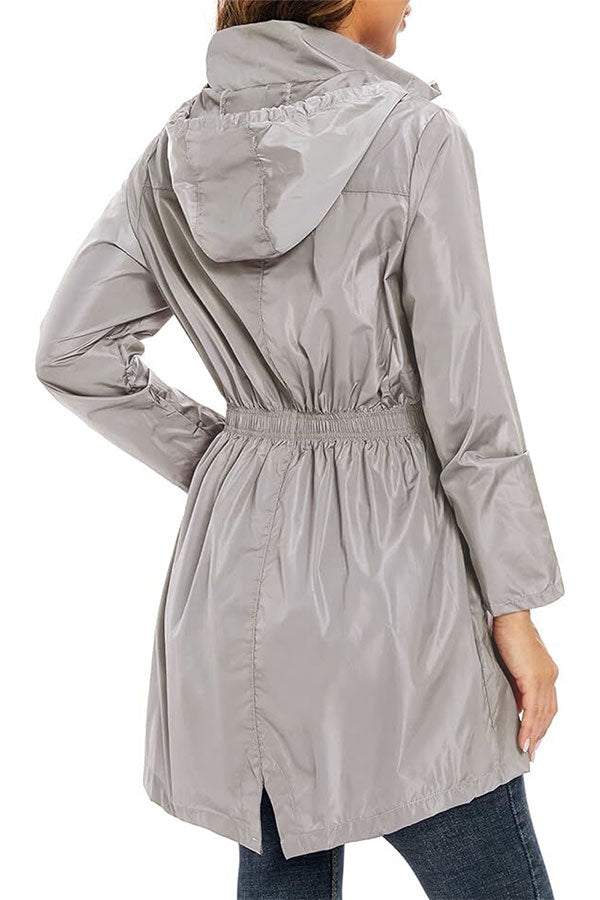 Woman wearing gray outdoor and travel hooded raincoat windbreaker jacket from the back